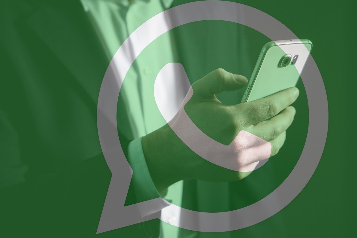 Simbolo WhatsApp e persona con smartphone in mano