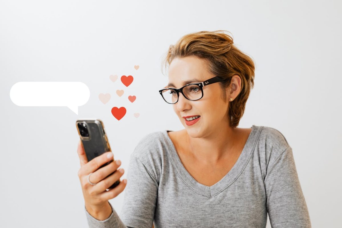 Donna che guarda lo smartphone con cuori