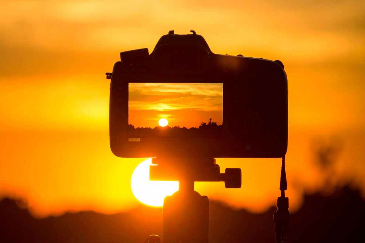 macchina fotografica davanti a un tramonto