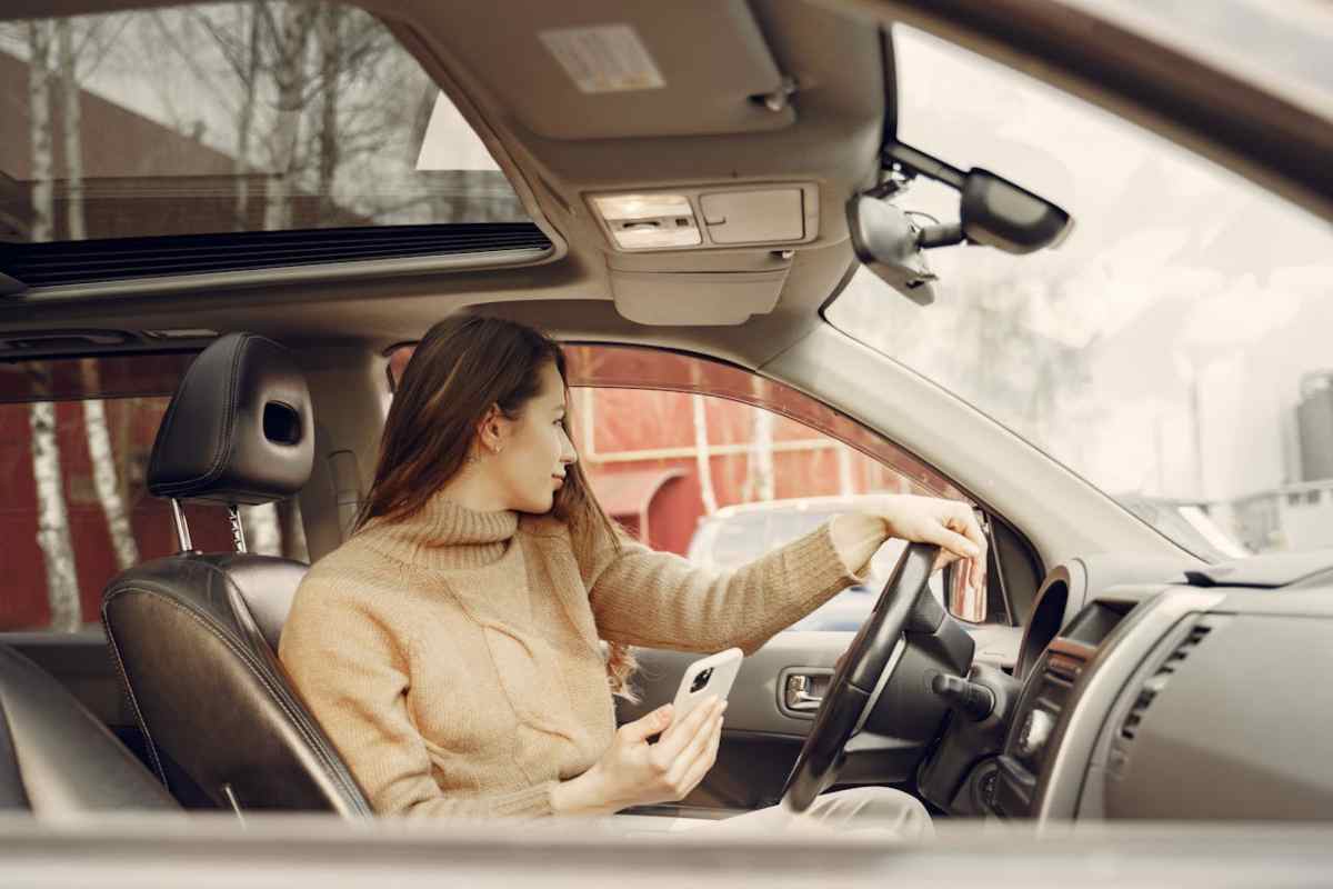 Donna in auto allo smartphone