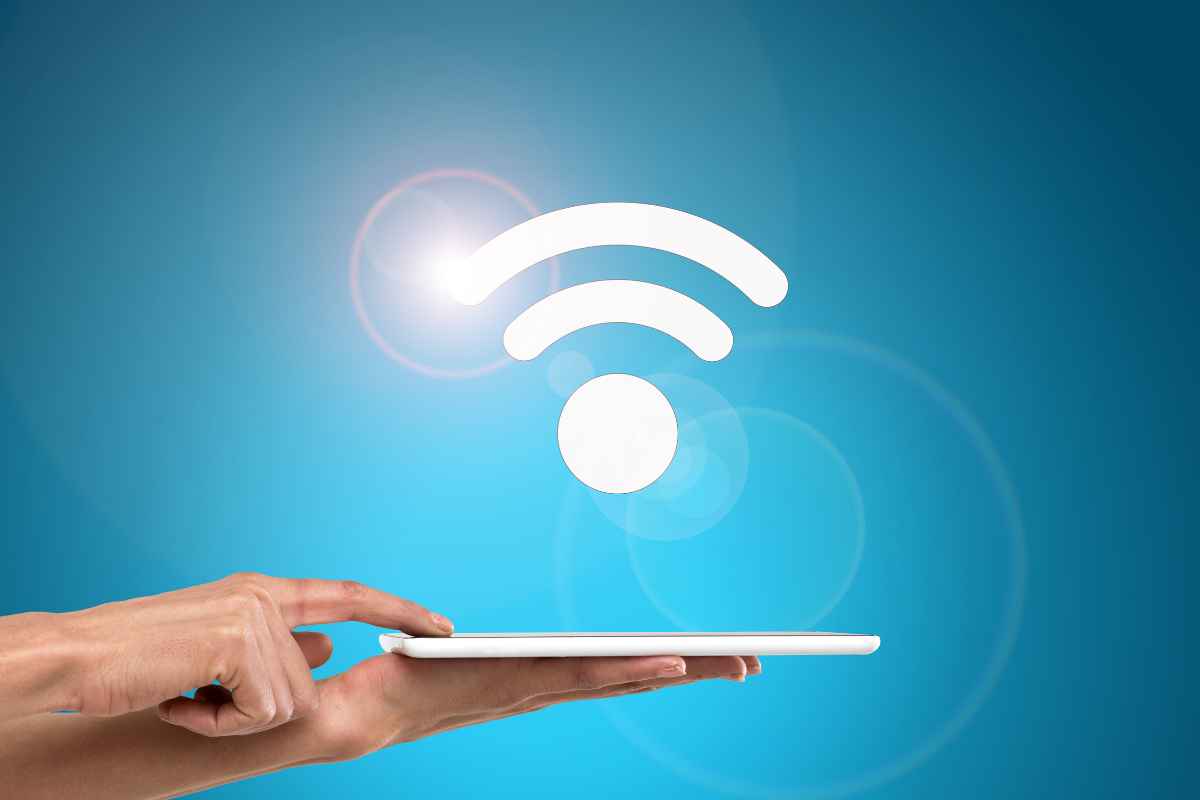 smartphone su una mano e logo wifi