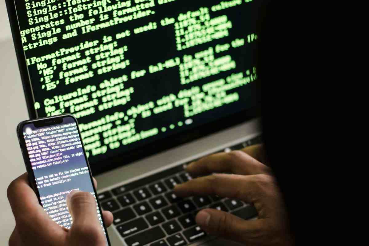 Hacker al laptop e smartphone