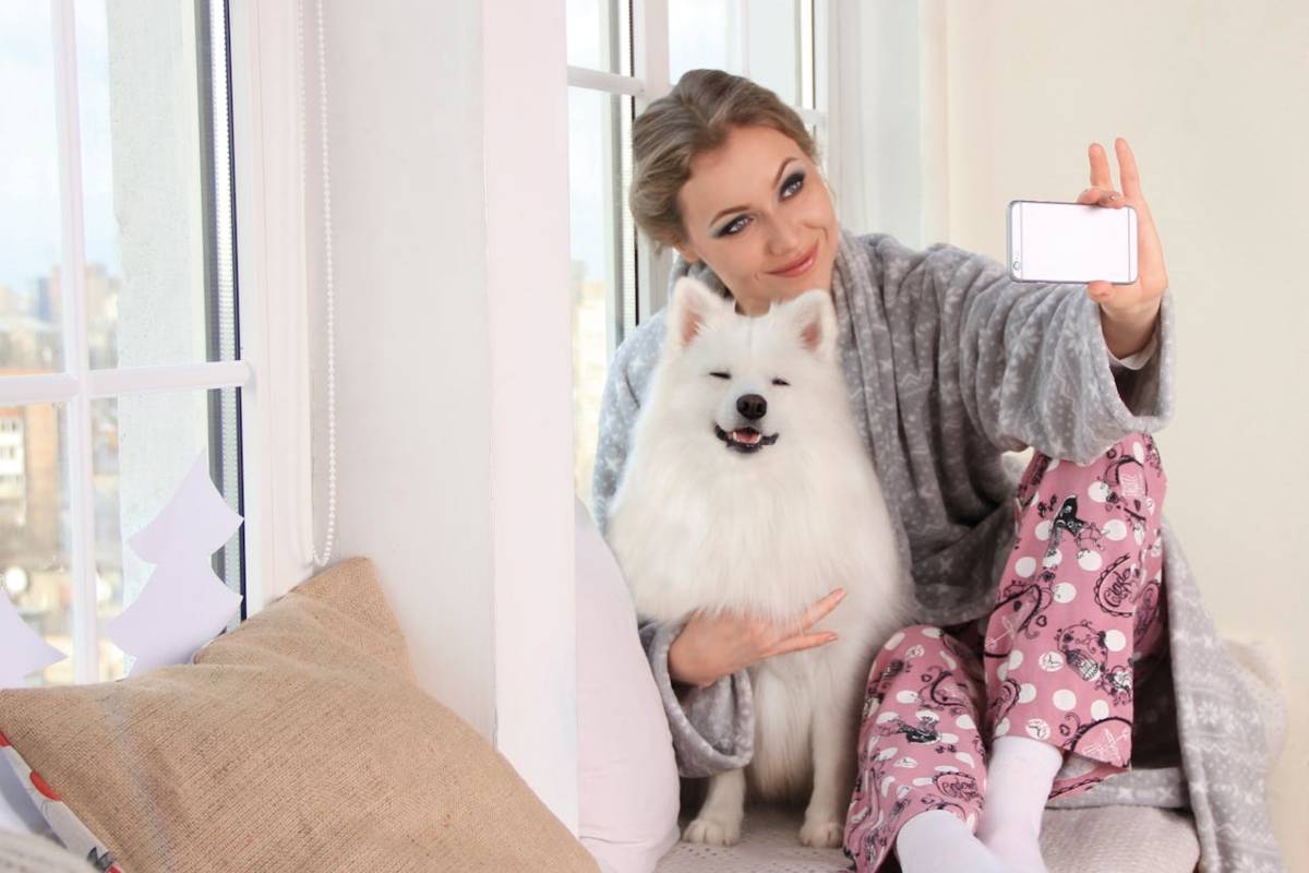 Ragazza che scatta selfie con cagnolino