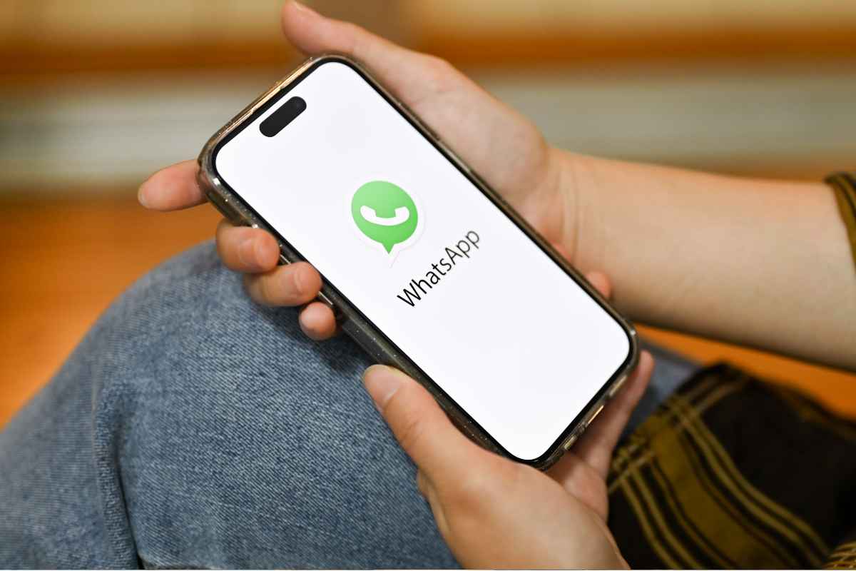 mano con smartphone sul cui schermo c'è il logo whatsapp