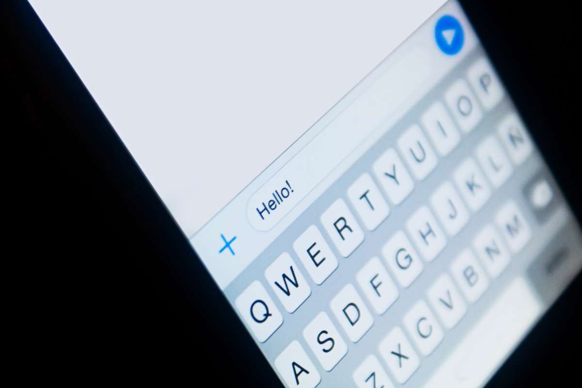 primo piano dello schermo di uno smartphone con la scritta hello