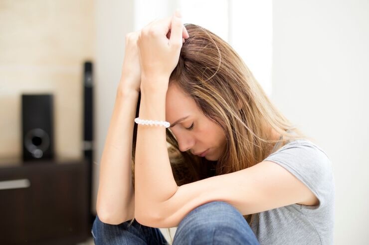Donna con mani sulla testa triste