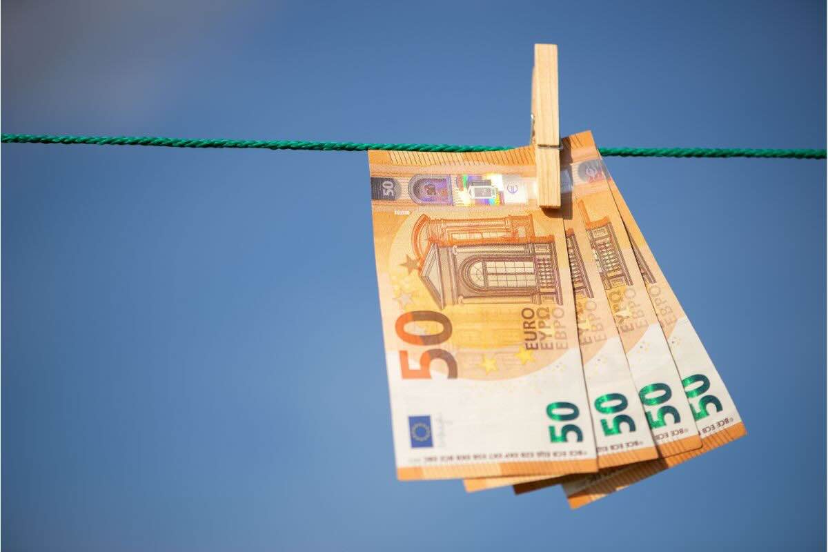 4 banconote da 50 euro stese appese ad un filo verde con molletta di legno
