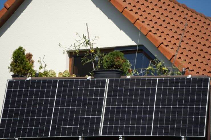 Pannello solare installato sulla ringhiera del balcone di una casa con tetto rosso