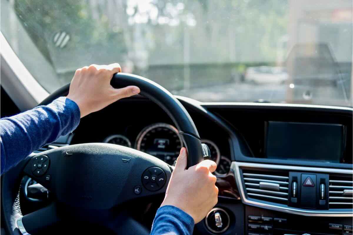 Mani di persona sul volante dell'auto