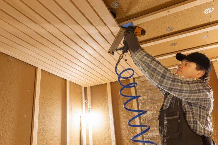 Tecnico che fa lavori su soffitto in legno 