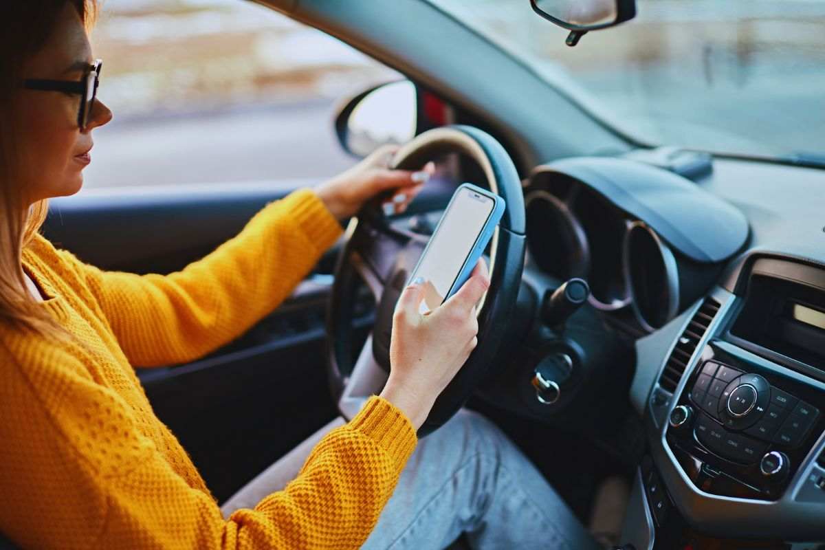 ragazza allo smartphone alla guida