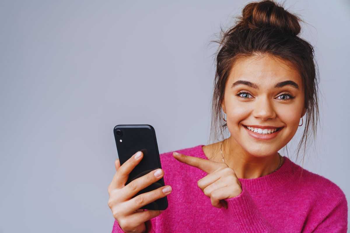 donna indica lo smartphone