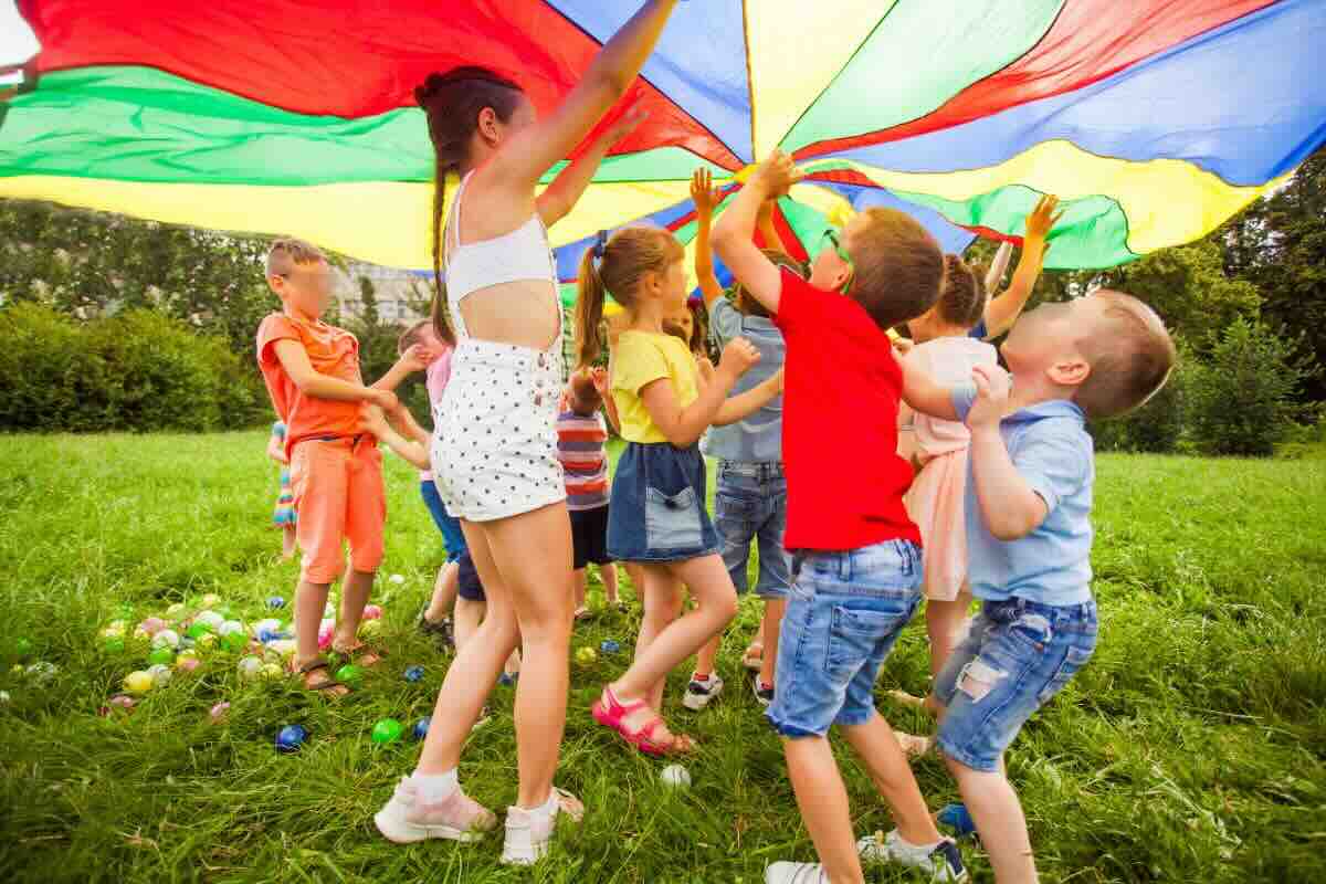 Bambini che giocano sotto un velo colorato arcobaleno