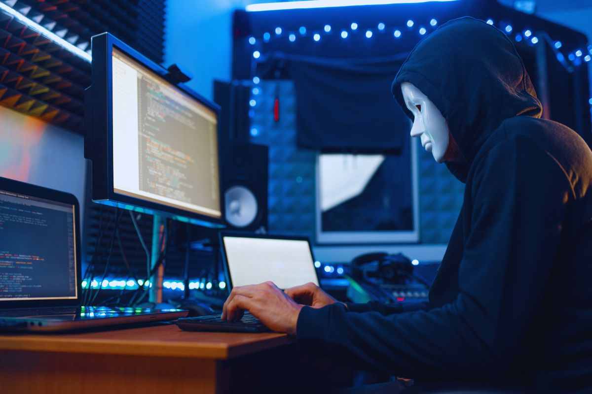 Uomo con maschera che lavora al Pc