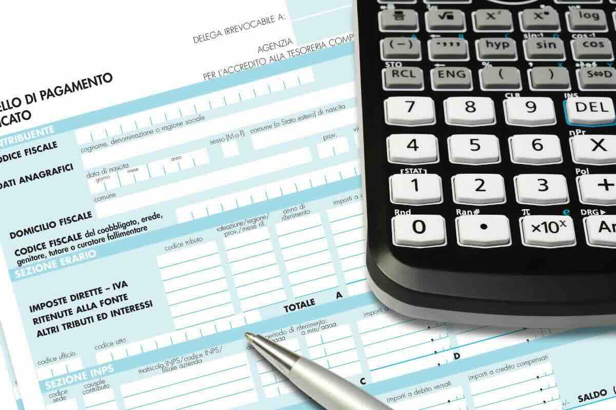 Modulo imposte bianco e azzurro, calcolatrice e penna