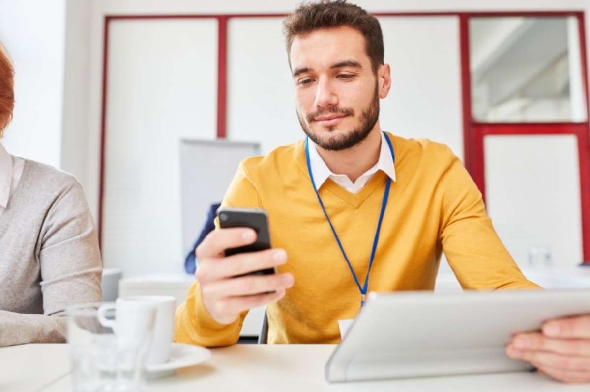 Uomo al lavoro controlla il cellulare