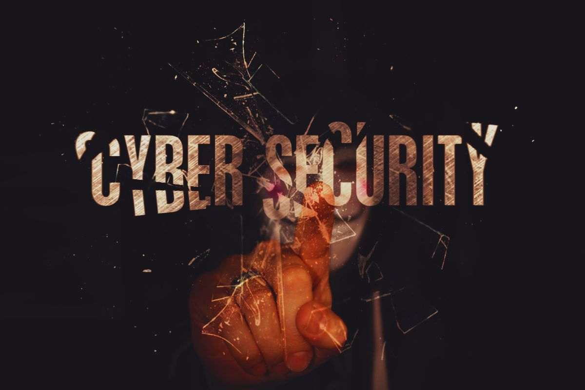 Hacker che spezza con dito la scritta "Cyber Security"