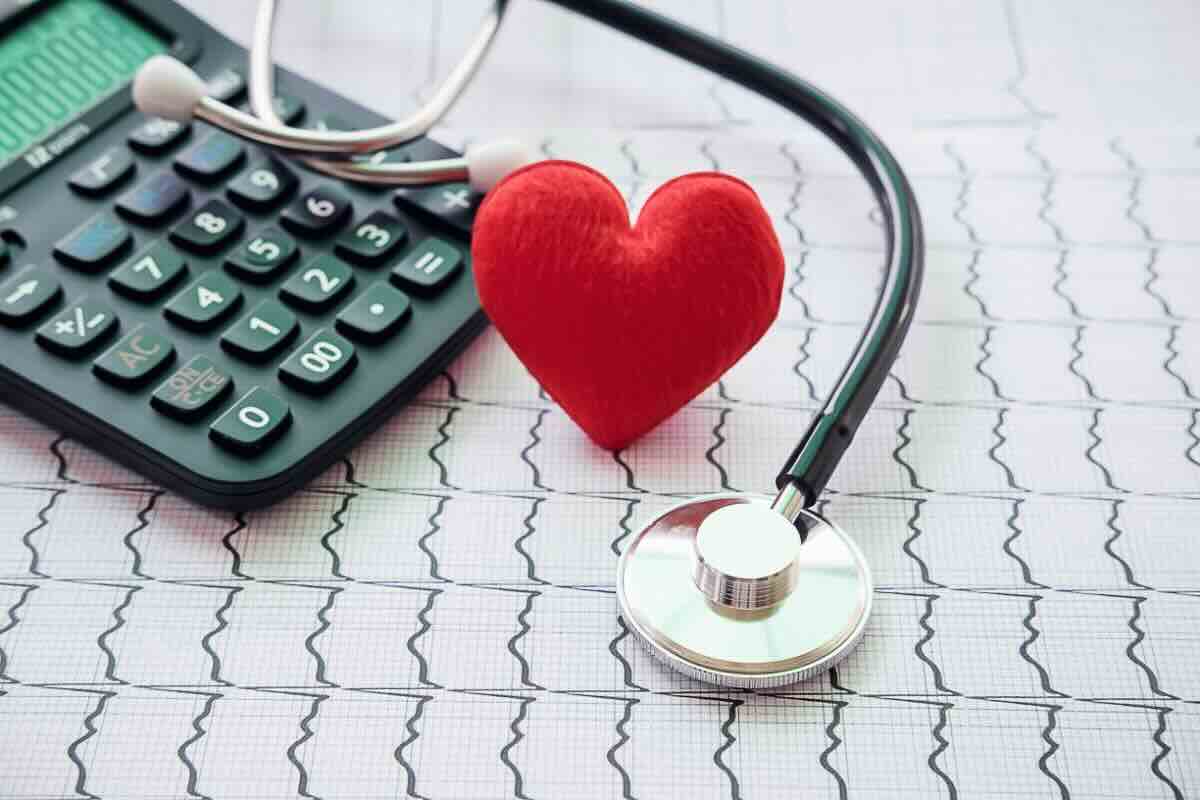 Foglio con elettrocardiogramma, calcolatrice, cuore, fonendoscopio