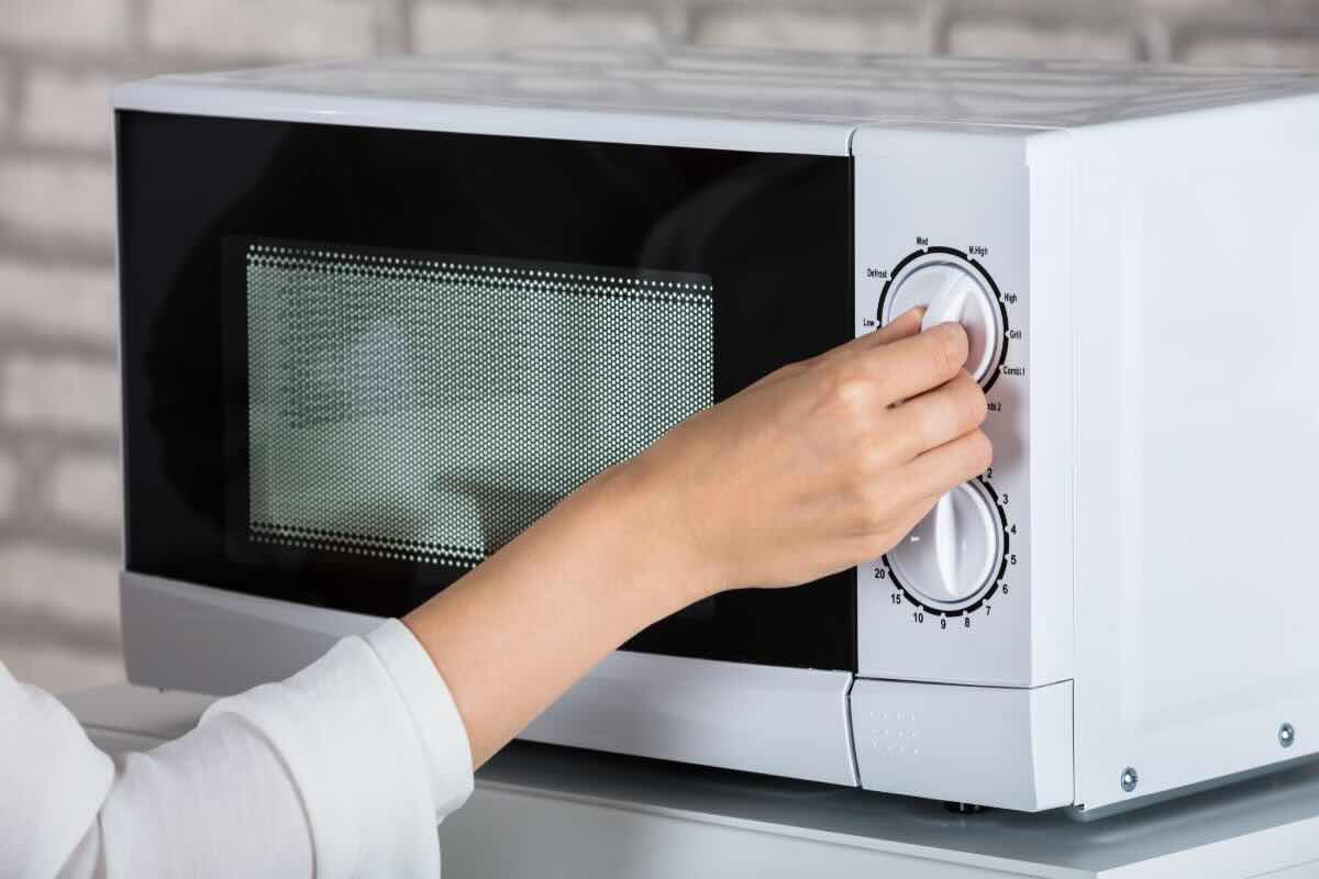 Mani di donna girano manopola microonde