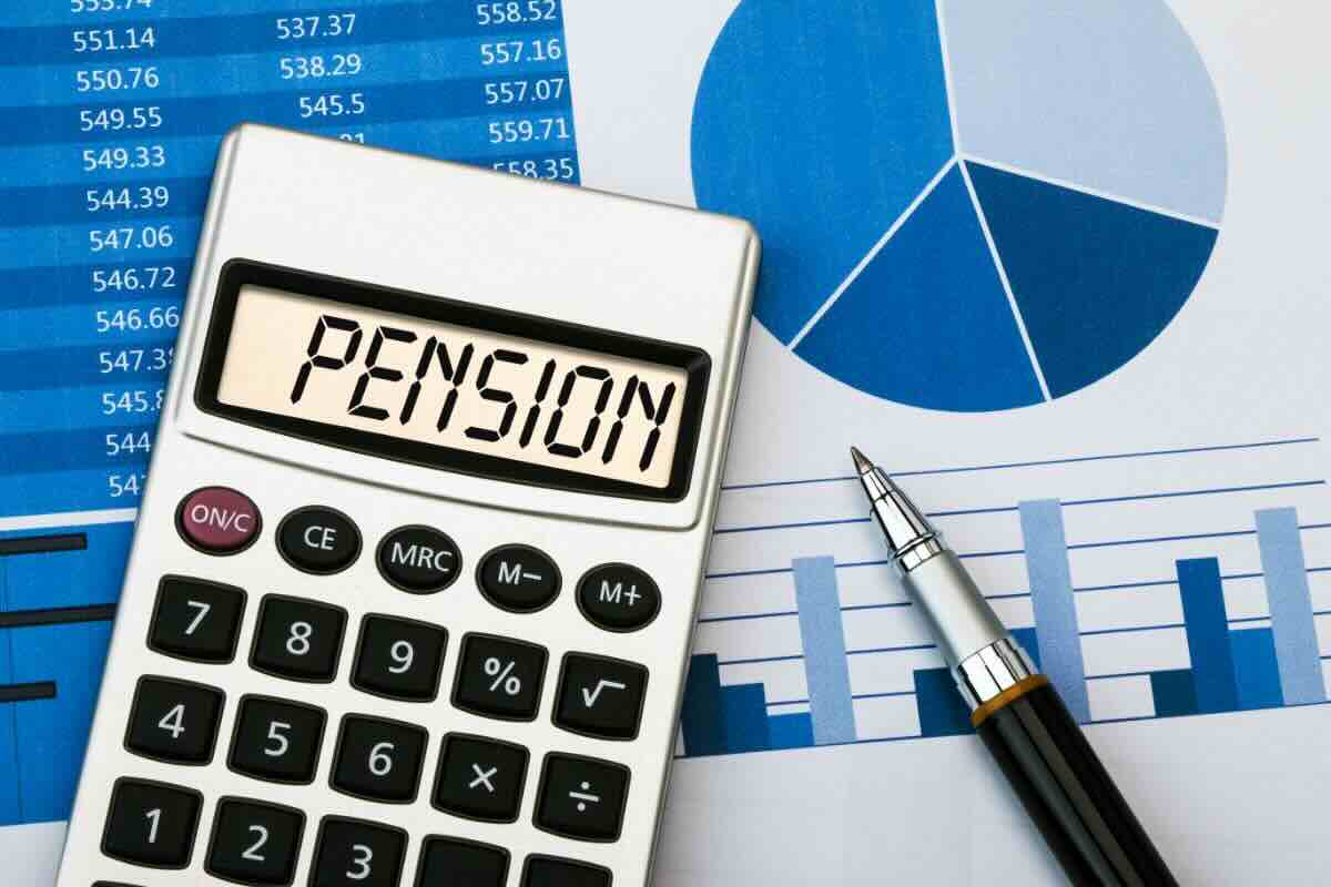 Calcolatrice con scritto "Pension", foglio con grafici, penna