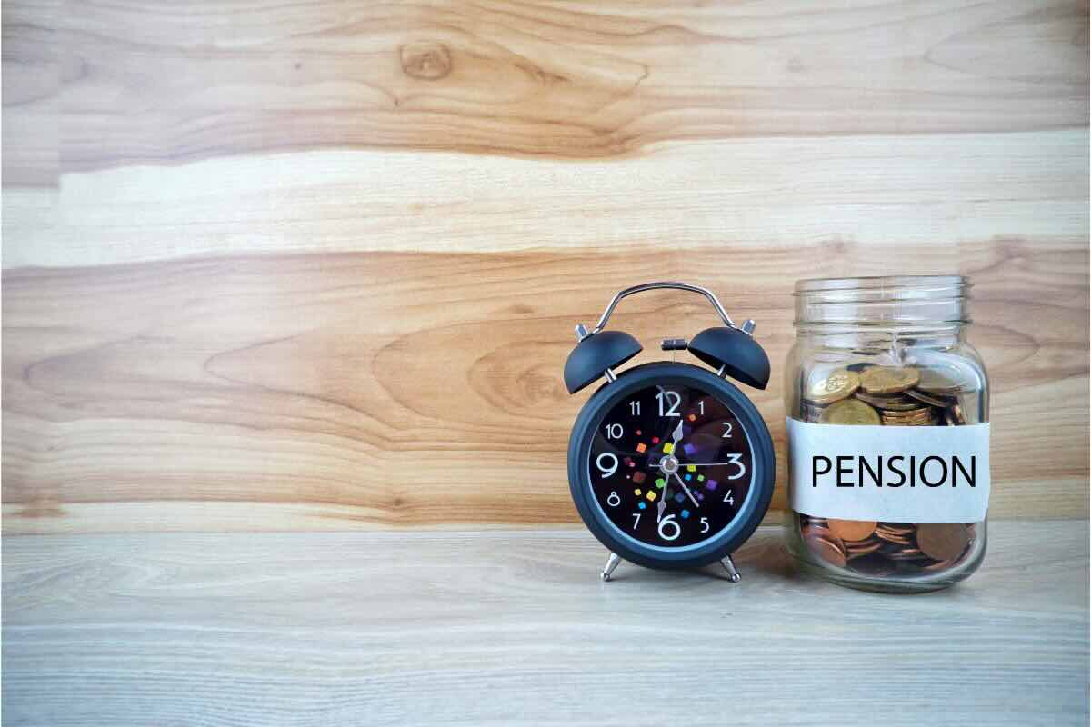 Sveglia e barattolo in vetro con monetine e scritta "Pension"