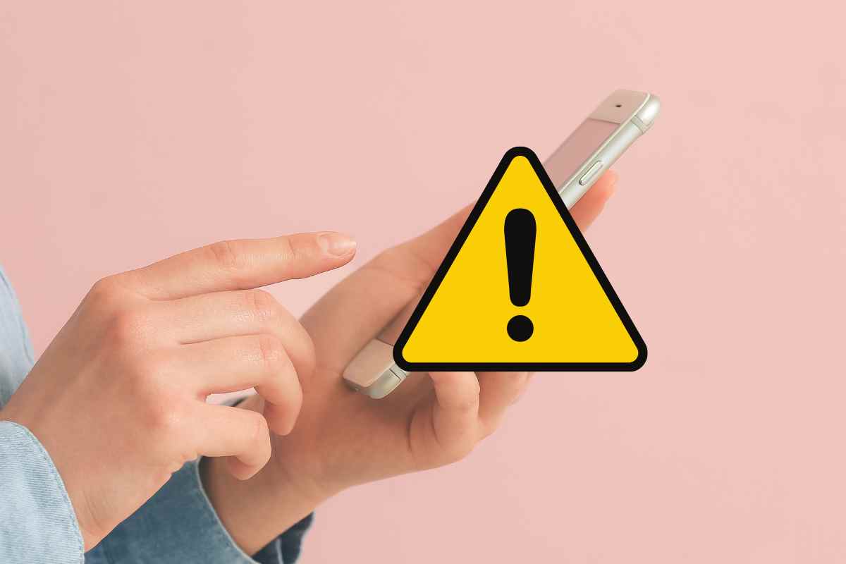 mani che usano un cellulare con il simbolo del triangolo giallo di perioclo