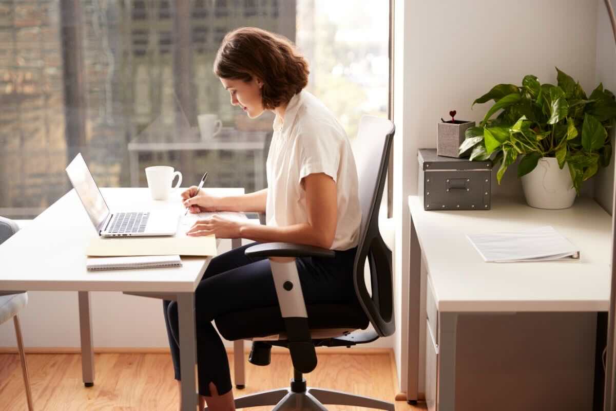 Ragazza seduta sulla sedia alla scrivania ufficio