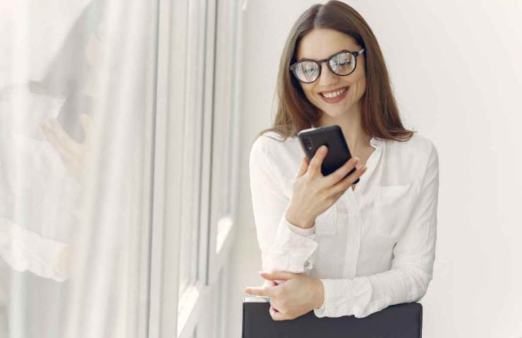 donna che guarda lo smartphone e sorride