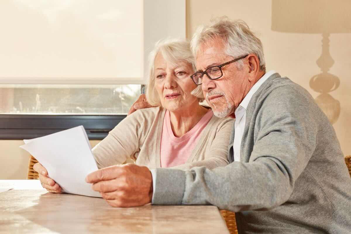 Uomo e dona anziani leggono un documento/foglio