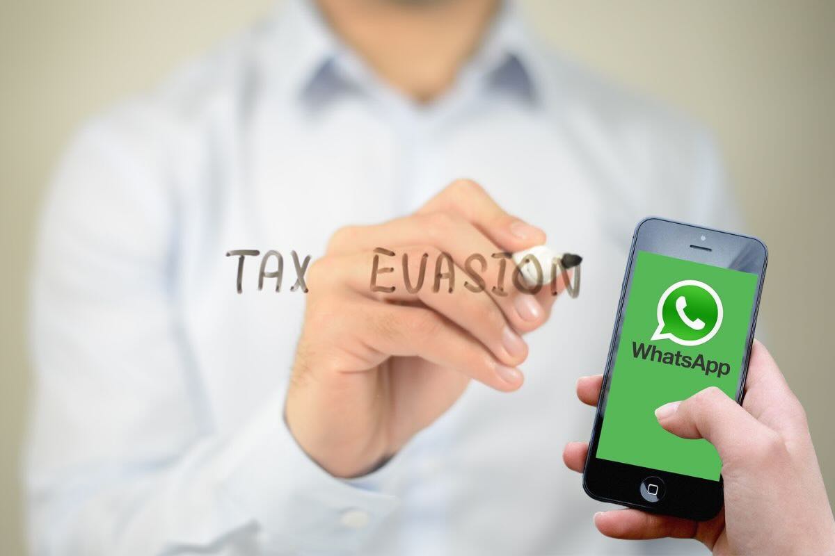 Mano scrive "tax evasion" e altra mano tiene smartphone con schermata whatsapp