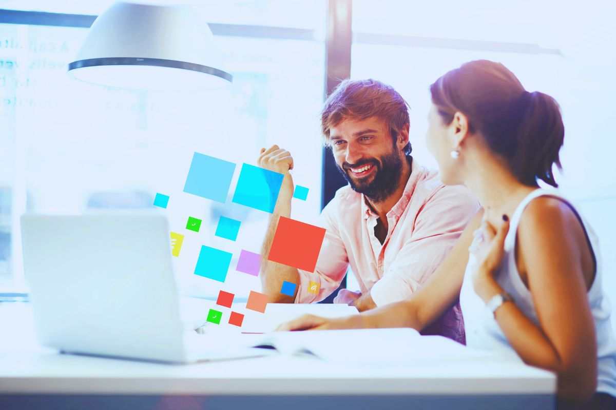 Uomo e donna sorridenti che lavorano al PC