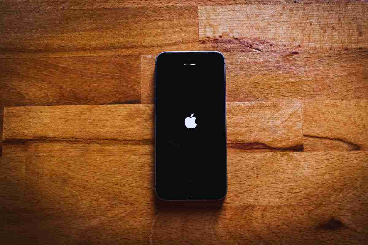 iPhone poggiato su tavolo di legno
