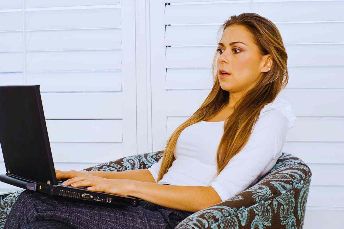 Ragazza con aria sconvolta che utilizza pc