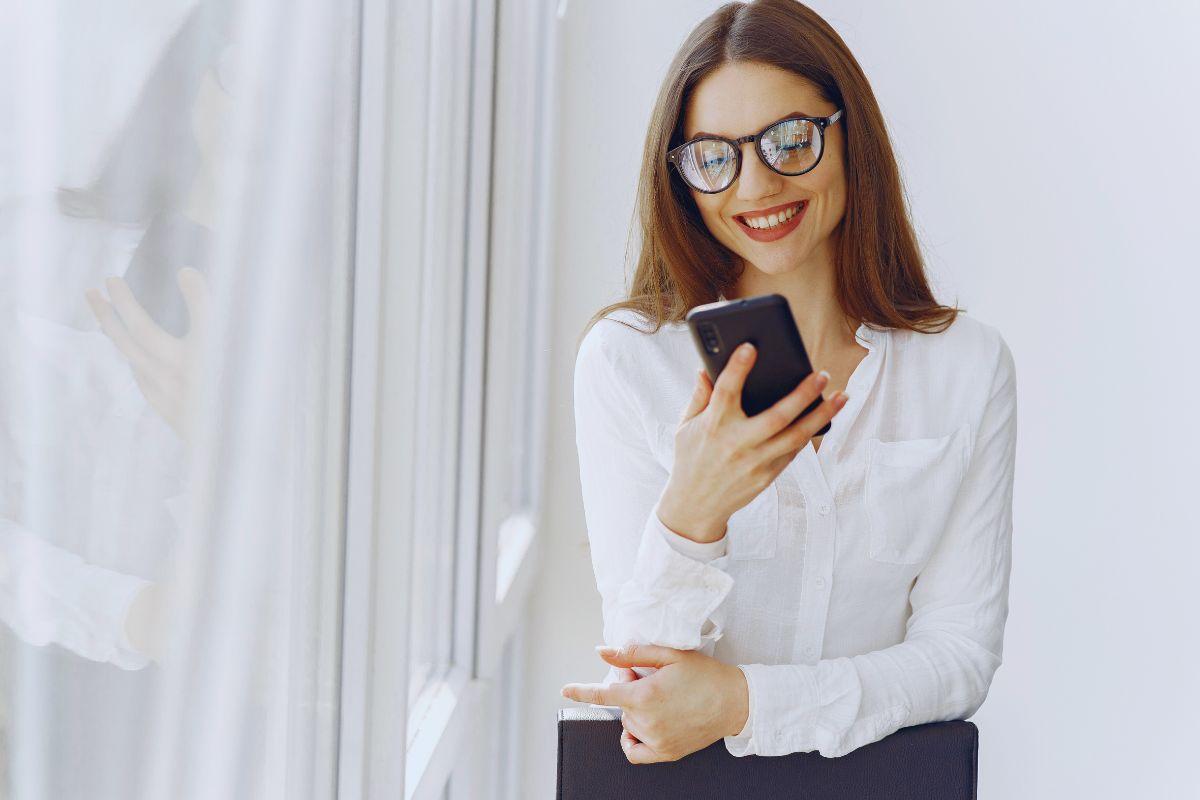 Ragazza sorridente che guarda lo smartphone