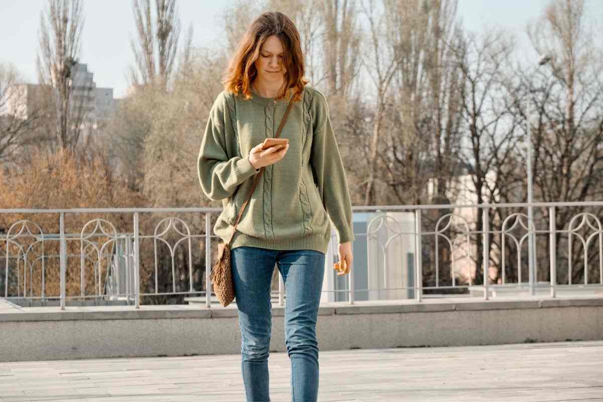 Ragazza passeggia con il telefono in mano