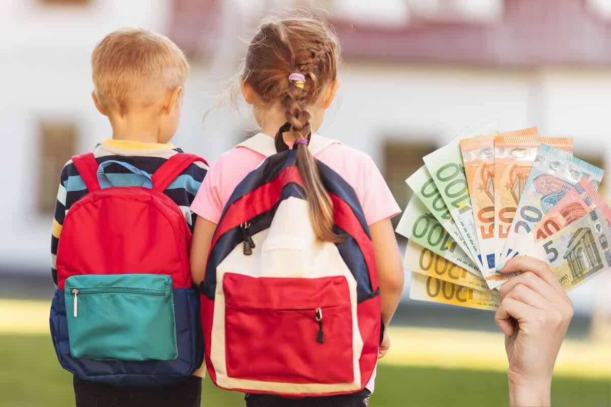 Due bambini con zaino scuola e mano con banconote euro