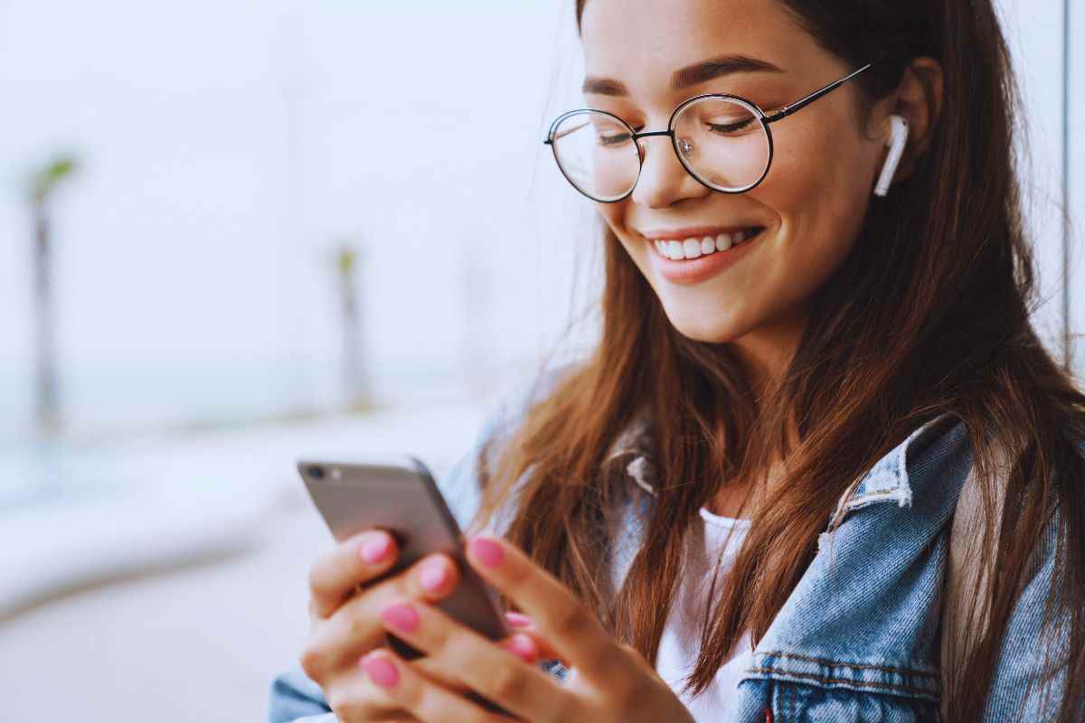 Ragazza sorridente con smartphone in mano