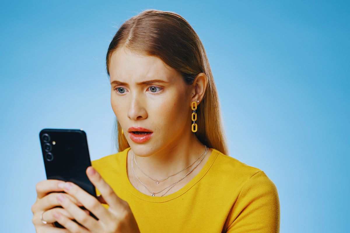 Ragazza dall'aria sconvolta che guarda il suo smartphone