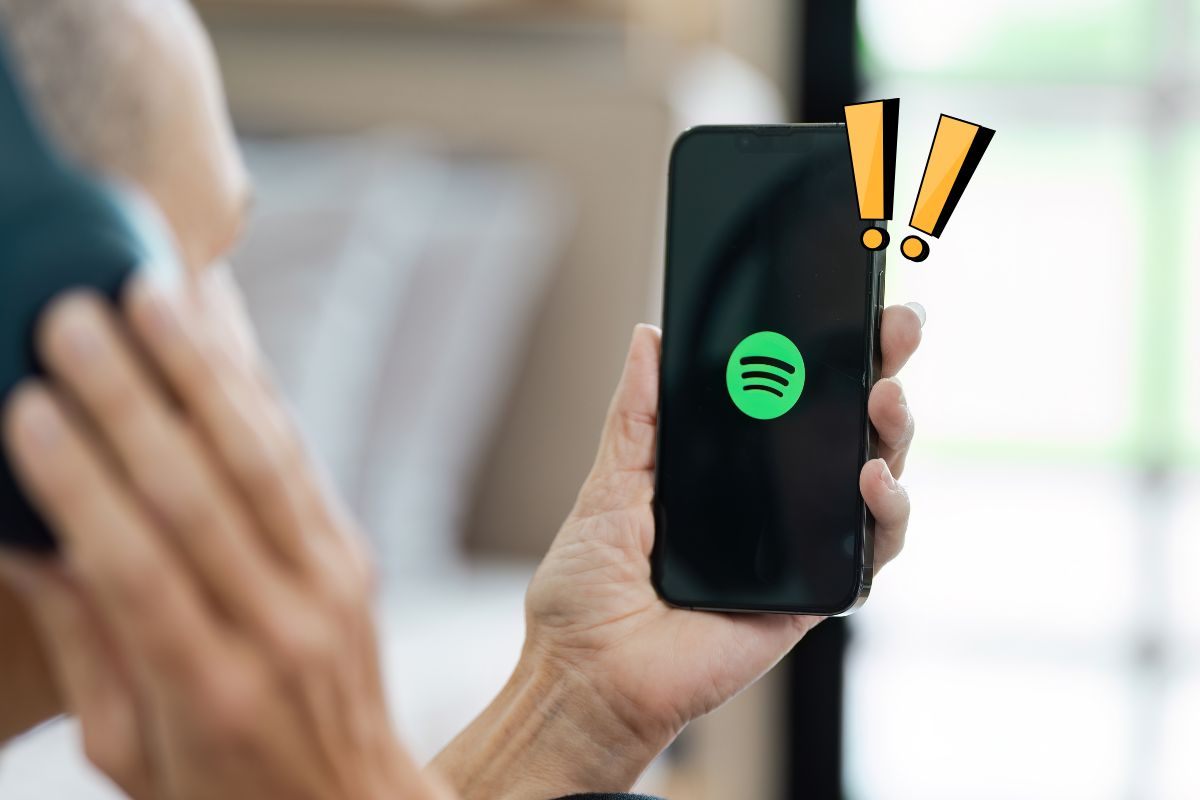Uomo apre applicazione Spotify sul telefono