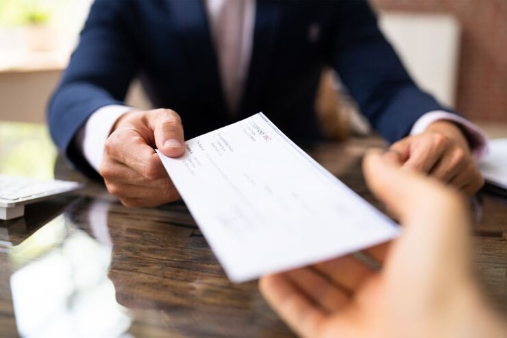 Uomo in giacca e cravatta passa documento ad un'altra mano