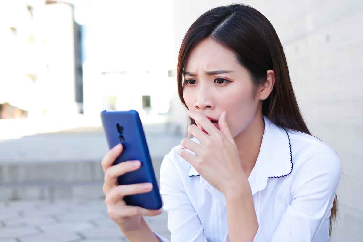 donna sorpresa che guarda lo smartphone