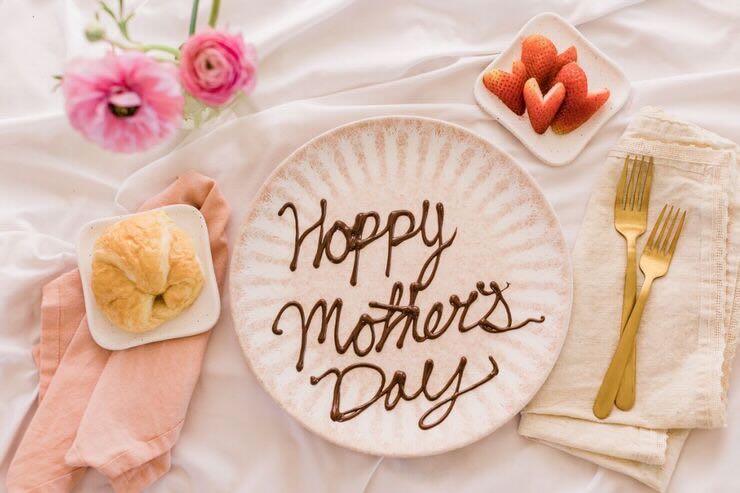 Fragole, fiori, piatto con scritto "Happy Mother's Day"