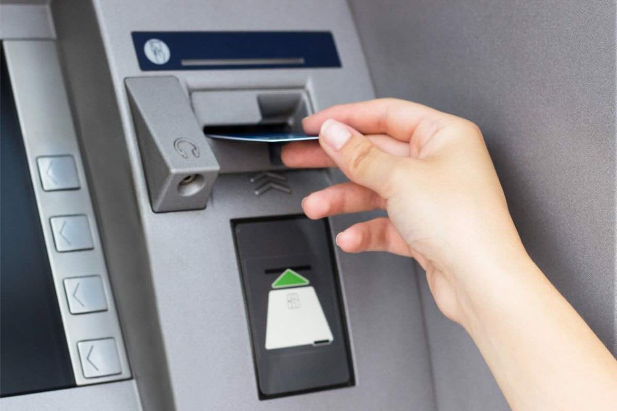 Mano inserisce carta nel bancomat