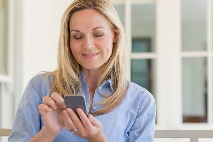 Donna bionda al cellulare, sorridente