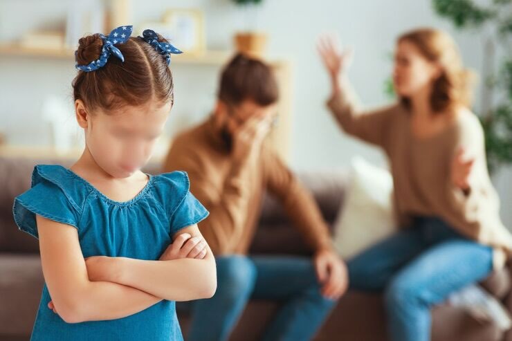 Genitori litigano sul fondo, bambina in primo piano triste