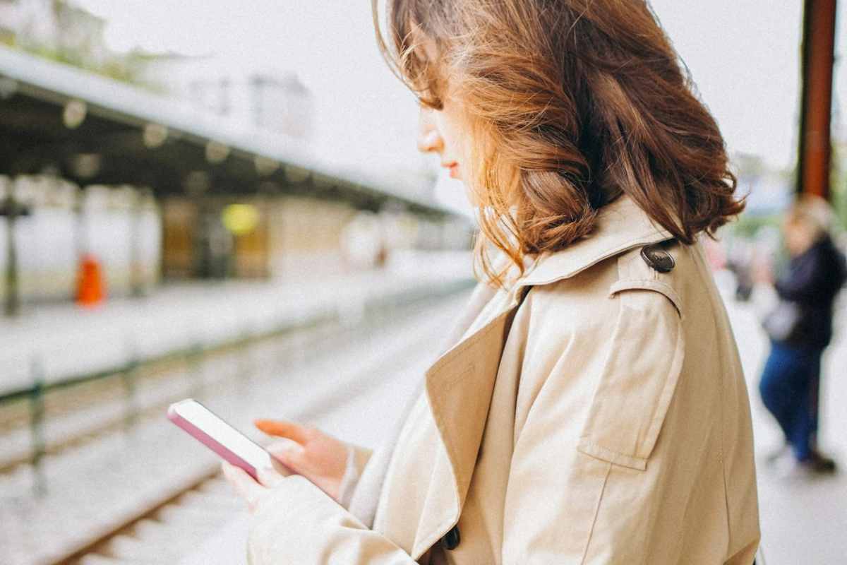 Ragazza allo smartphone che prende mezzi di trasporto