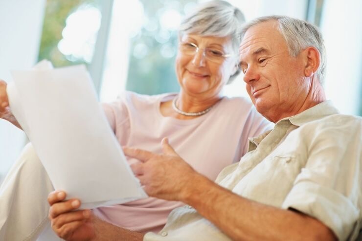Uomo e donna leggono un documento sorridenti 