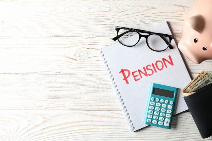 Quaderno con scritto in rosso "Pension", occhiali da vista, calcolatrice