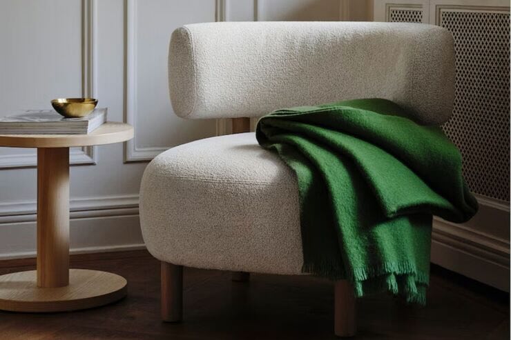Poltrona con plaid verde inserita in una stanza