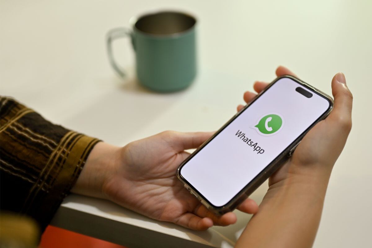 Mano tiene smartphone con schermata Whatsapp